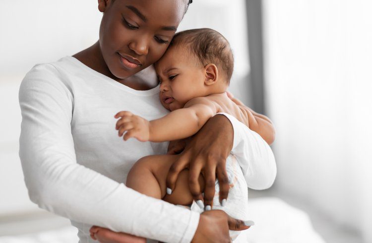 A woman holding a baby in her arms.